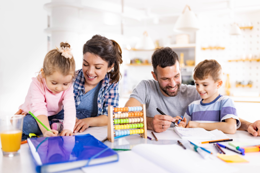 Parents helping their young children with schoolwork at home, using notebooks, pens, and an abacus.