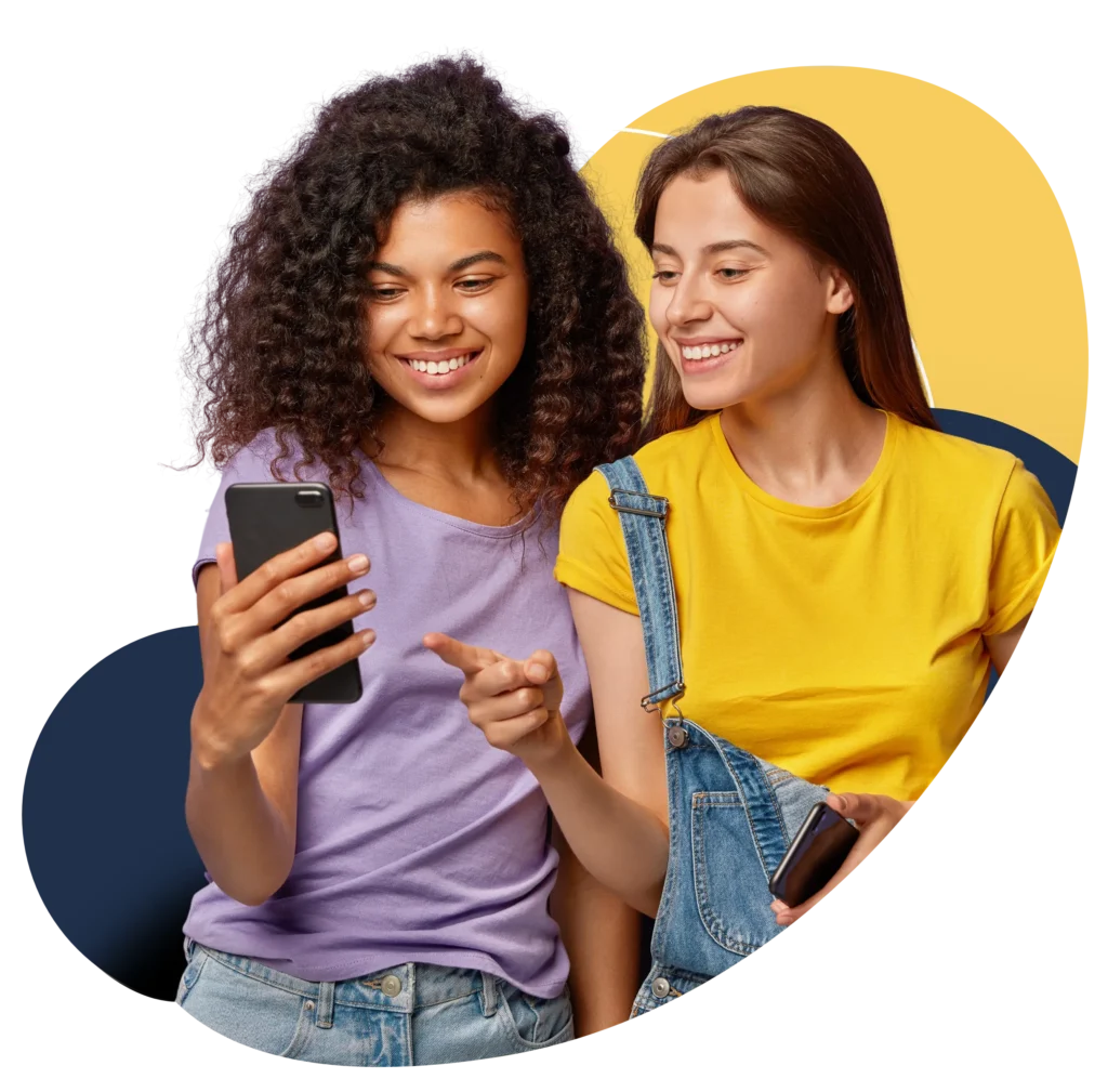 two girls looking and pointing at mobile phone